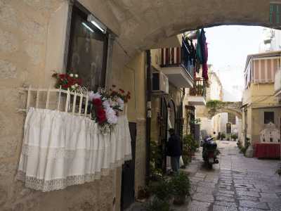 Sbuchiamo in strada delle Crociate, "sede" della Corte Alberolungo. Tanto per cambiare l'ingresso � rappresentato da un arco con tanto di edicola votiva, abbellita da un dipinto ottocentesco di olio su rame dell�artista Vito Dentamaro raffigurante l'Addolorata tra santi